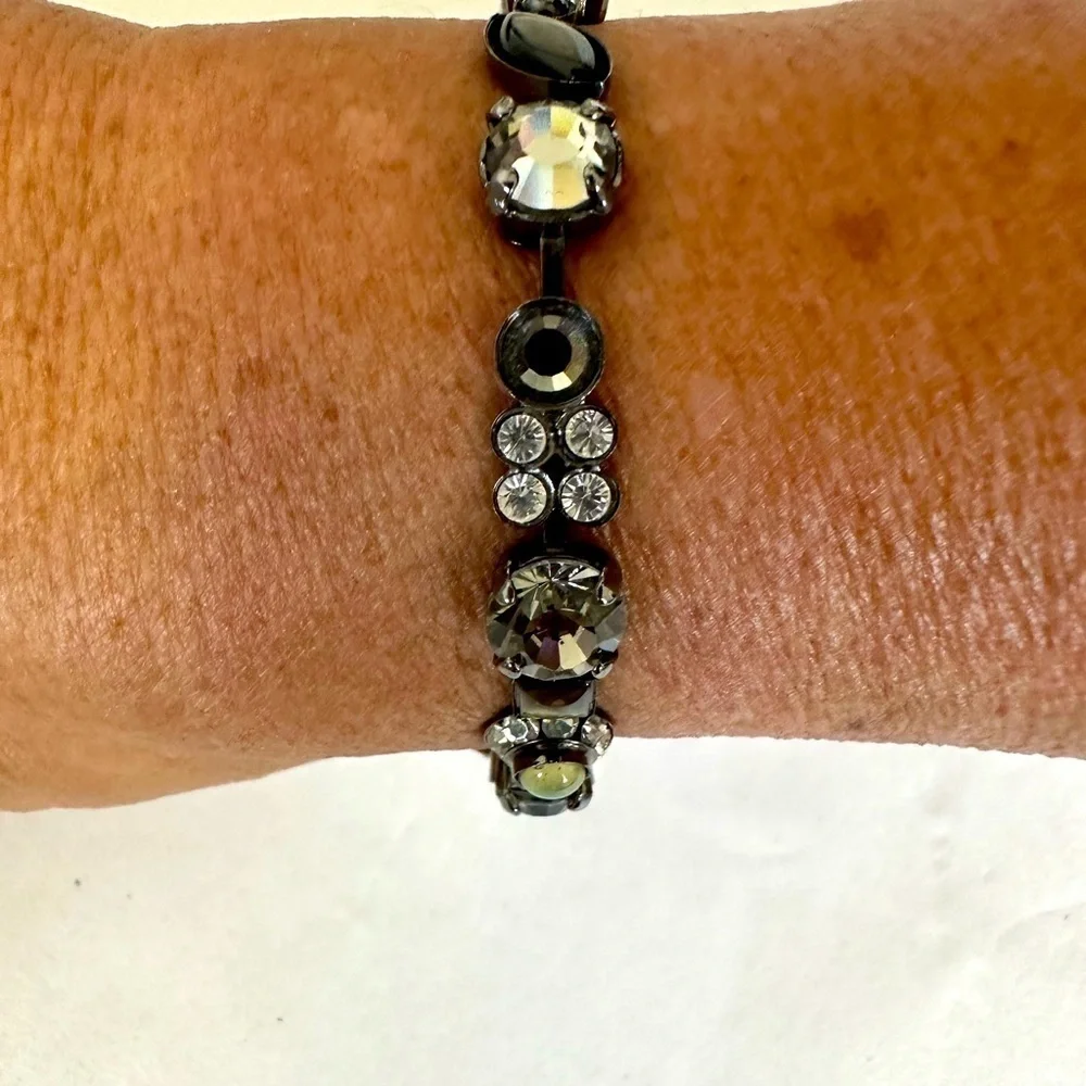 Multi-stone bracelet prone set in Nickel colored metal 7” . Stone are varied.